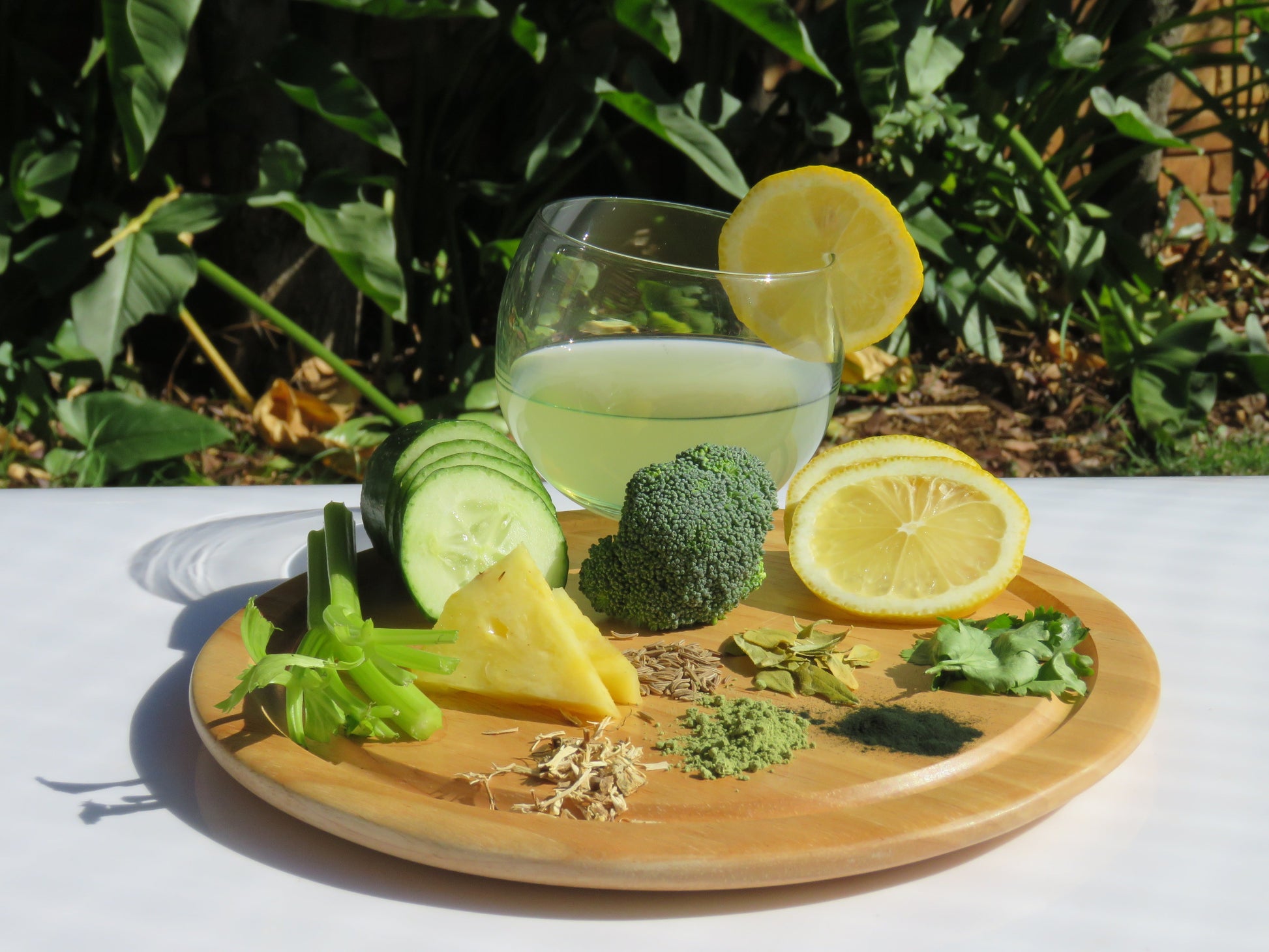 A refreshing glass of Green Cuisine Water Kefir with a display of all the ingredients.