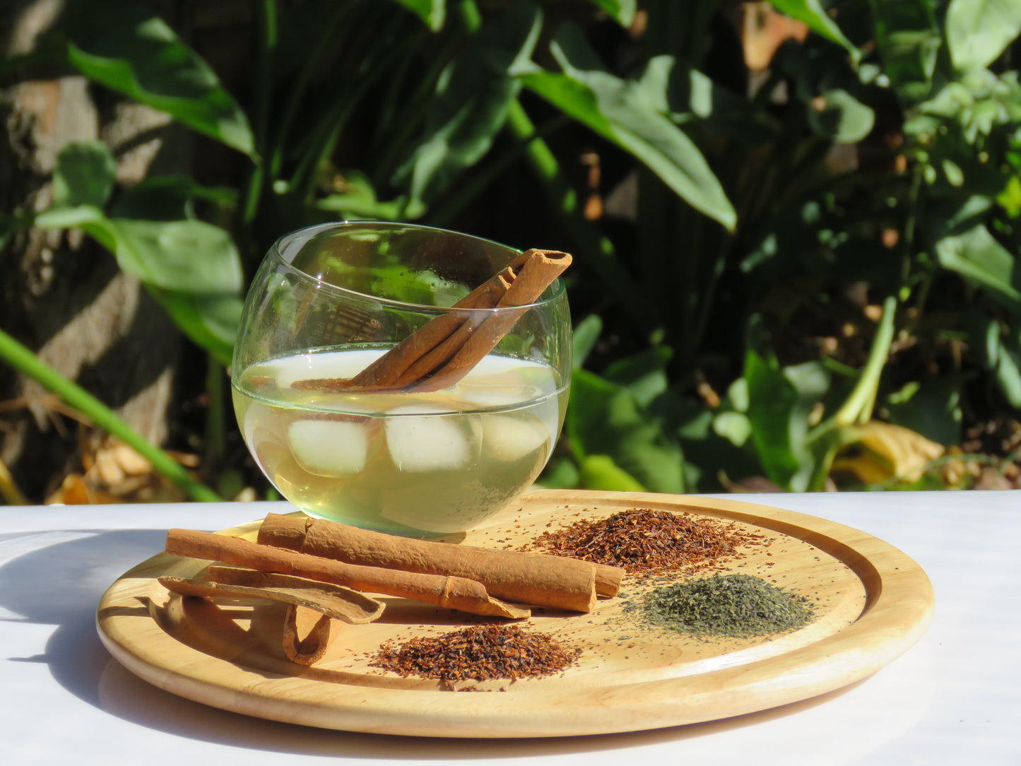 A refreshing glass of Teas & Cinnamon Kombucha with a display of all the ingredients.