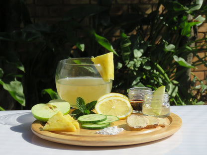 A refreshing glass of pH Regulator Water Kefir with a display of all the ingredients.