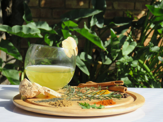 A refreshing glass of Spicy Vitality Kombucha with a display of all the ingredients.