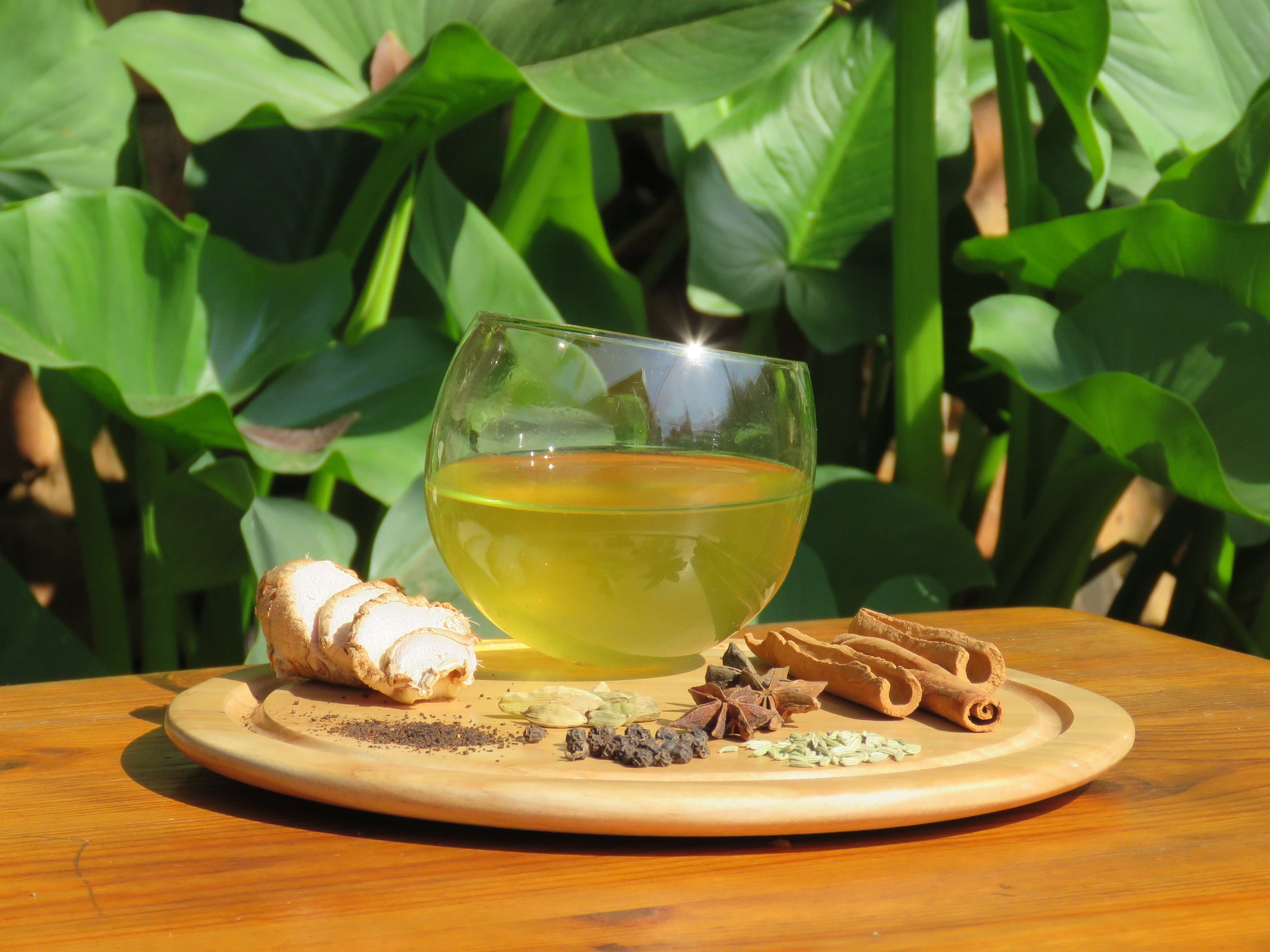 A refreshing glass of Chai Tea Kombucha with a display of all the ingredients.